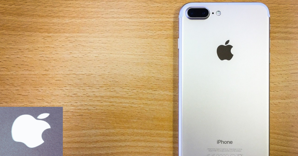 Iphone cor prata sobre a mesa de madeira